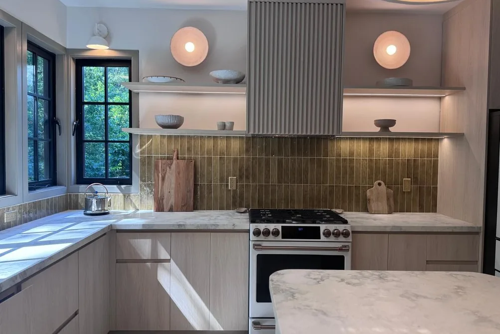 Fluted cabinet wall, stone counters and gas range in the installed US kitchen