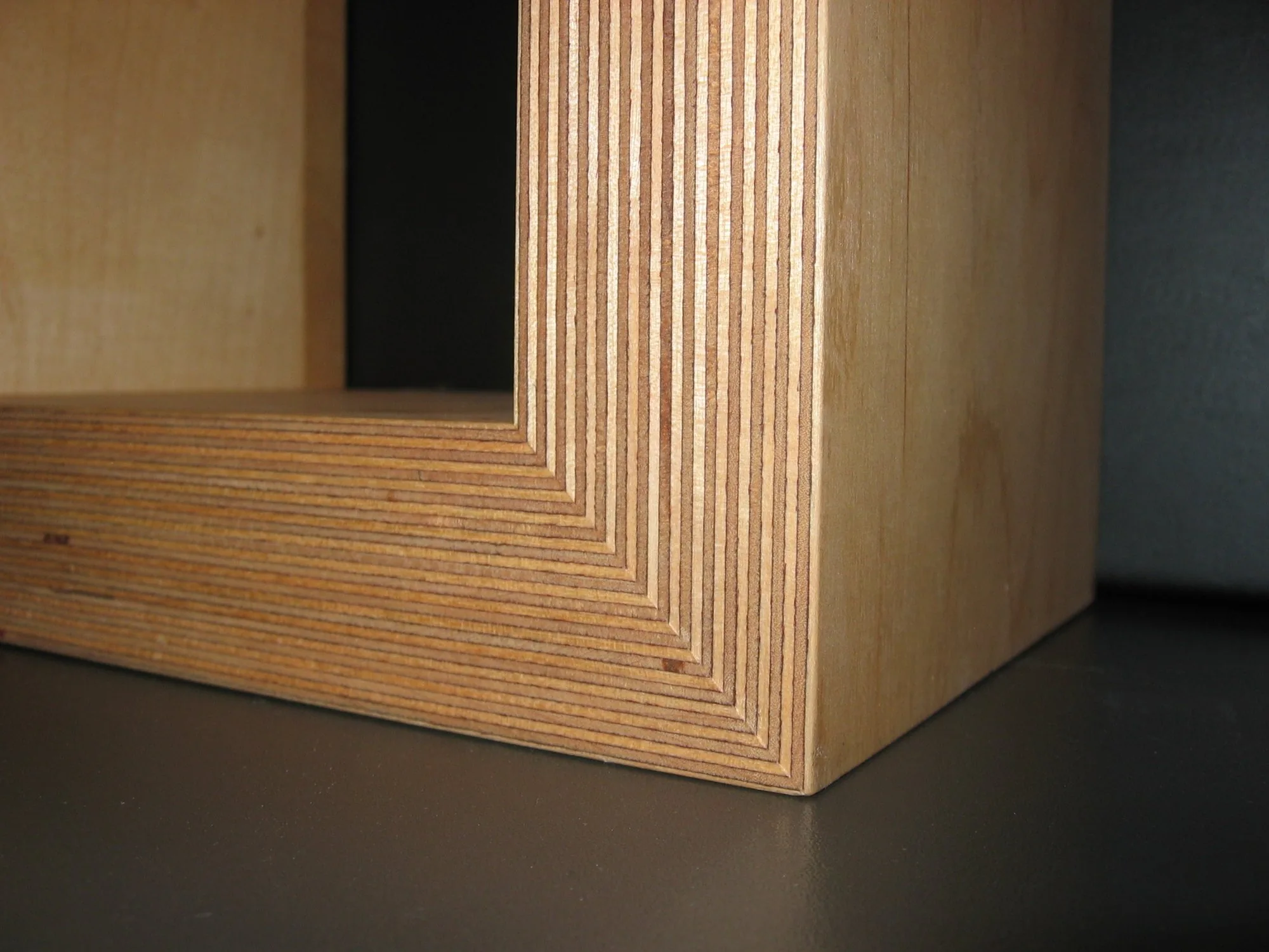 Edge of a stacked plywood panel showing the layered core, the material named under heading 4412 of the tariff schedule