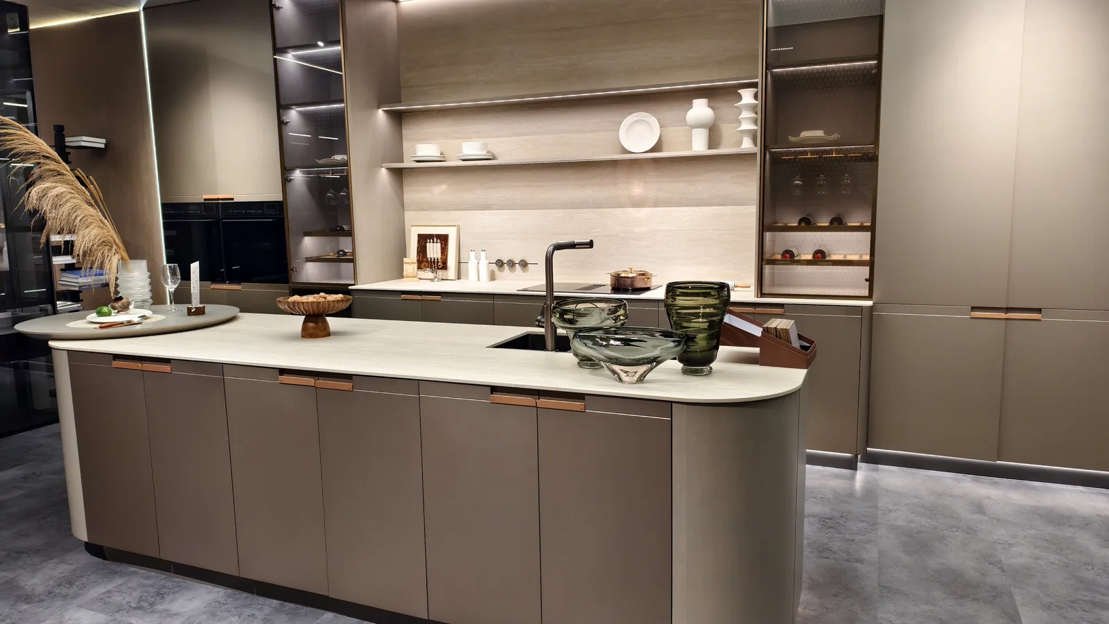 Warm grey kitchen with an open stone-topped island and full-height panelled tall units