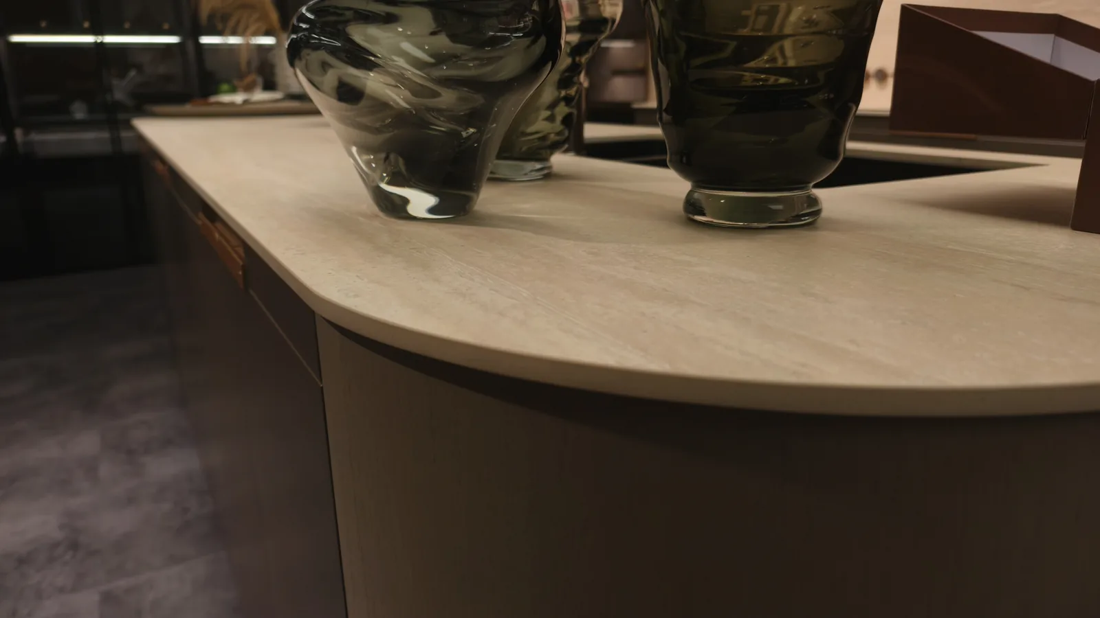 Close view of a stone worktop edge meeting a dark timber cabinet front