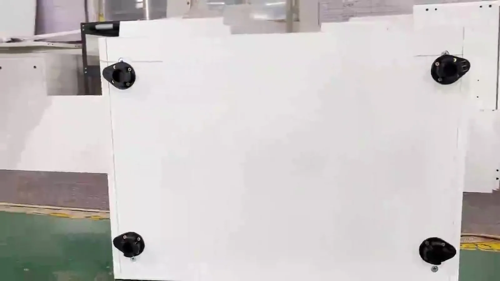 White cabinet base panel with four adjustable feet on the factory floor