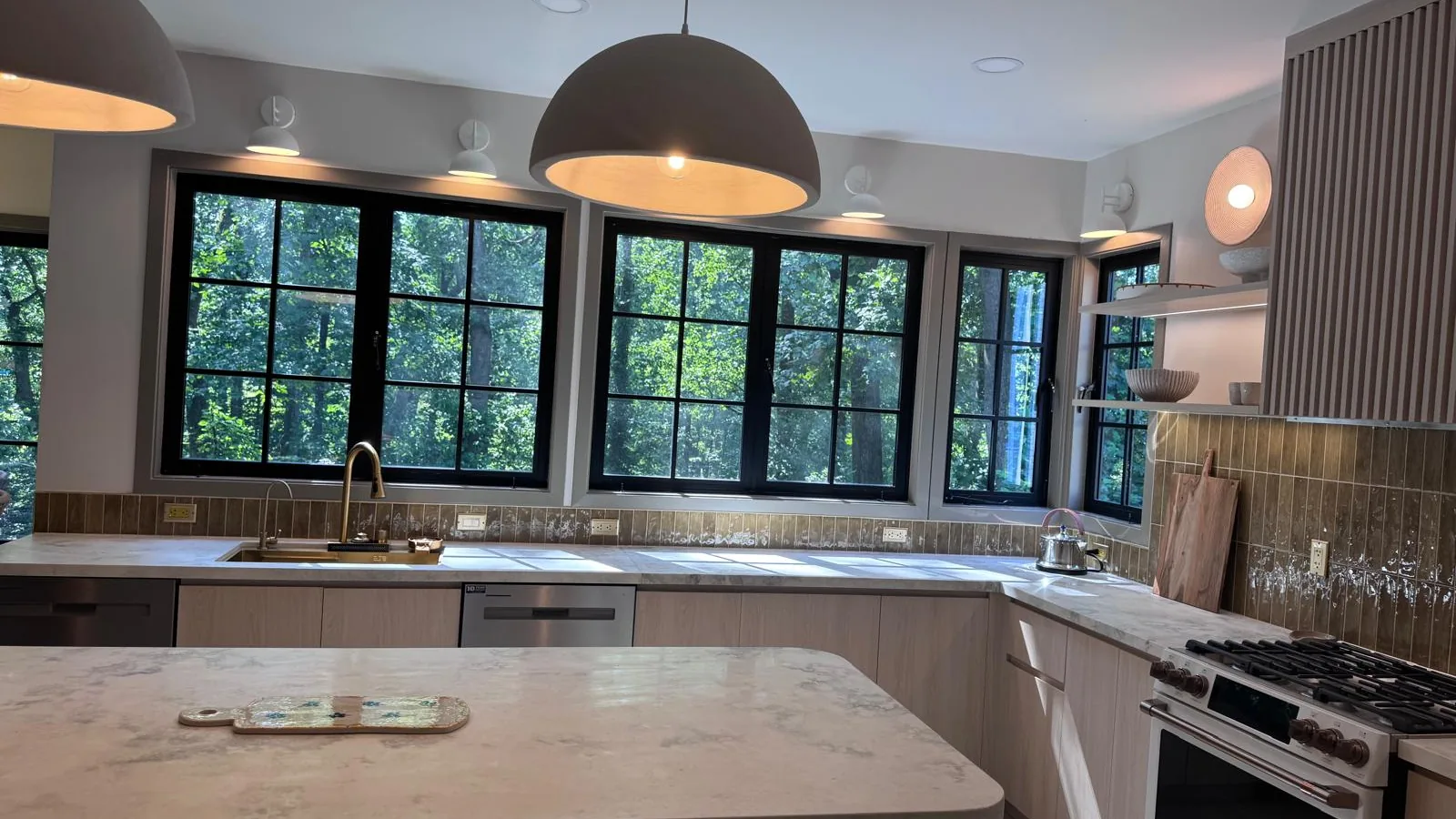 Light oak kitchen with marble-look quartz island and louvered tall unit