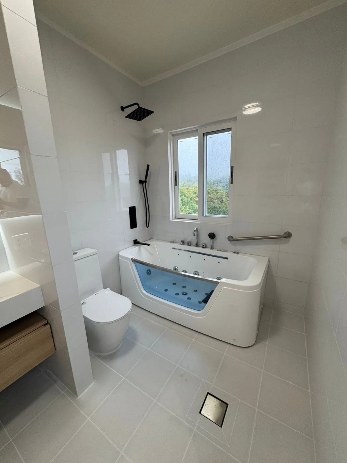 Unit bath with freestanding tub, walk-in shower and white walls