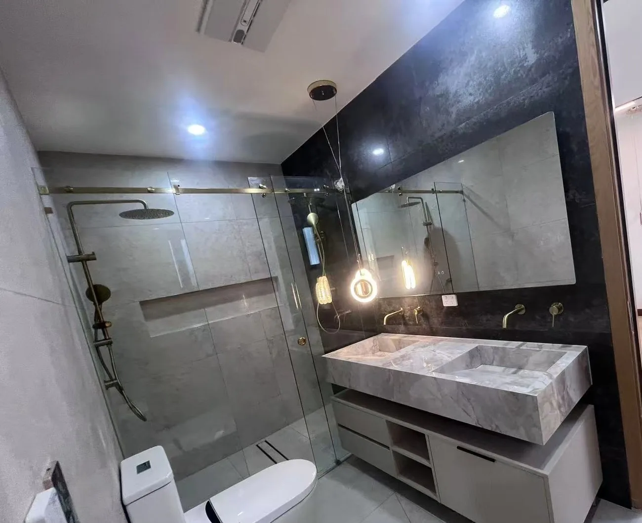 Bathroom with stone basins and dark mirror wall, UK