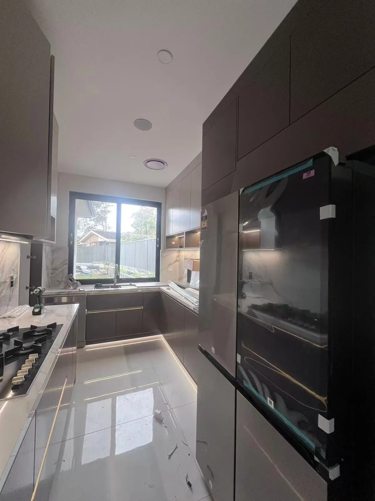 Black tall kitchen run with built-in ovens, UK