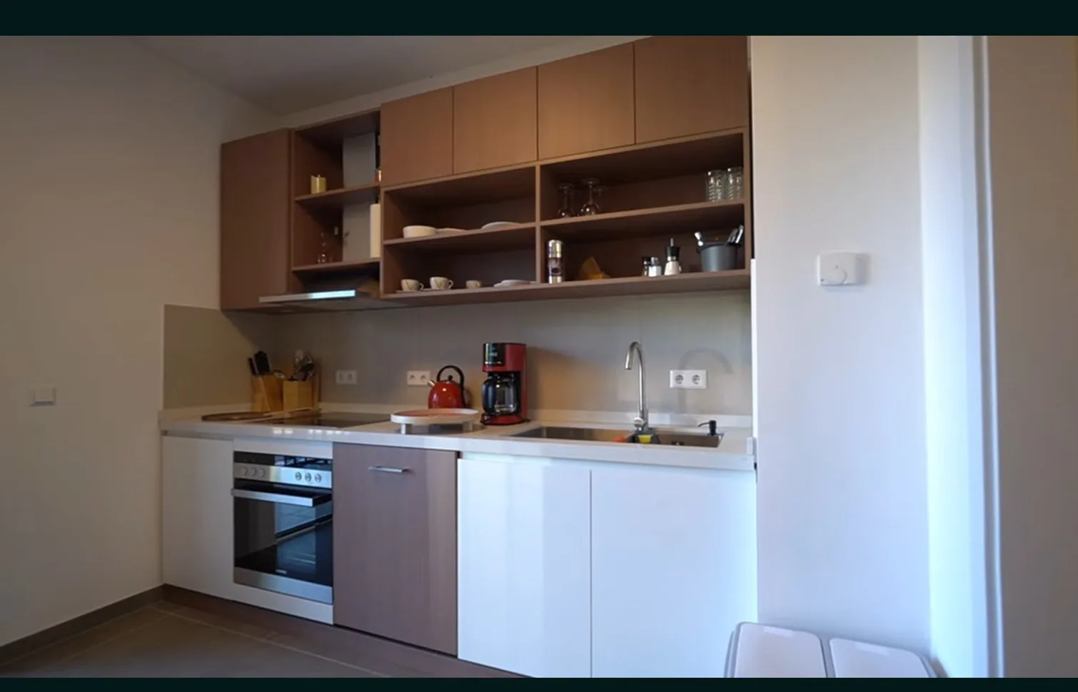 White and walnut kitchen with built-in ovens, UK