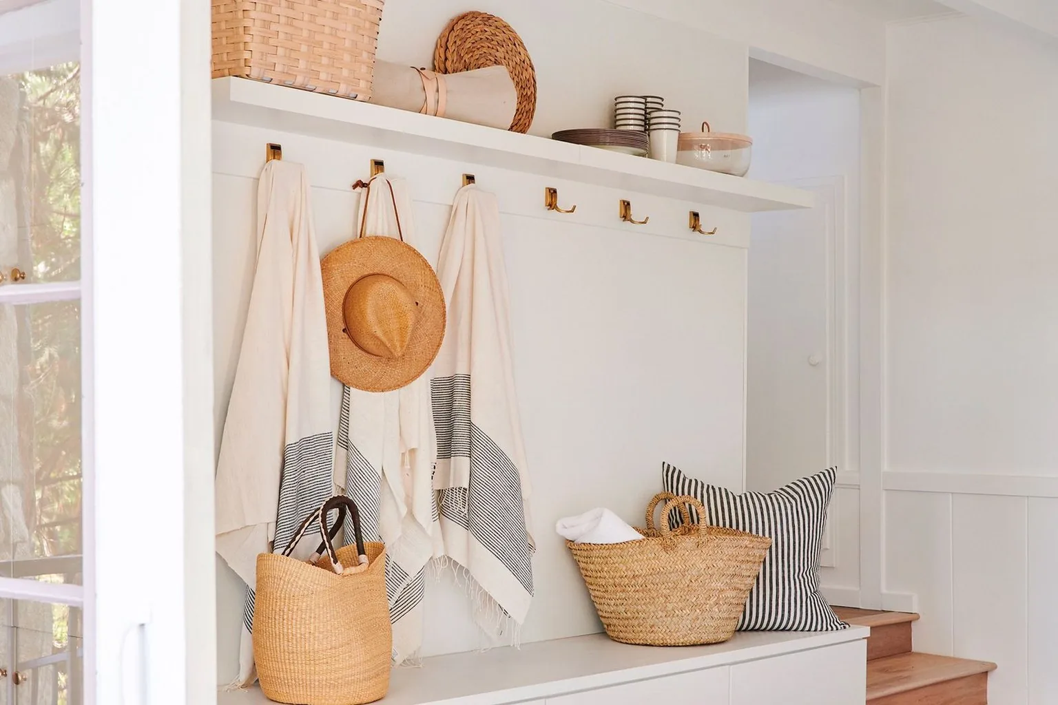 White apartment entry run with hooks, bench and baskets