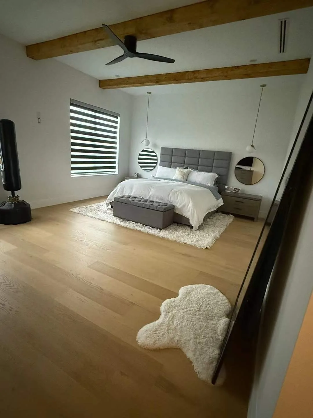 Unit bedroom with wood ceiling beams and white bedding