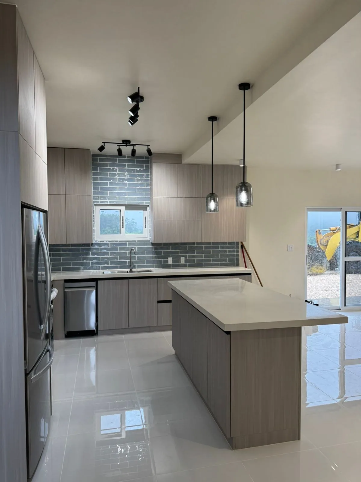 Kitchen with light oak island, pendants and gray tile floor