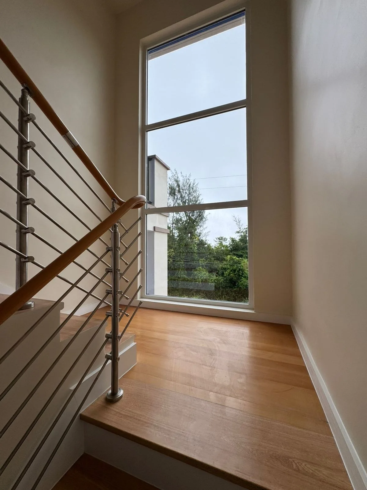 Stair landing with wood floor and full-height window