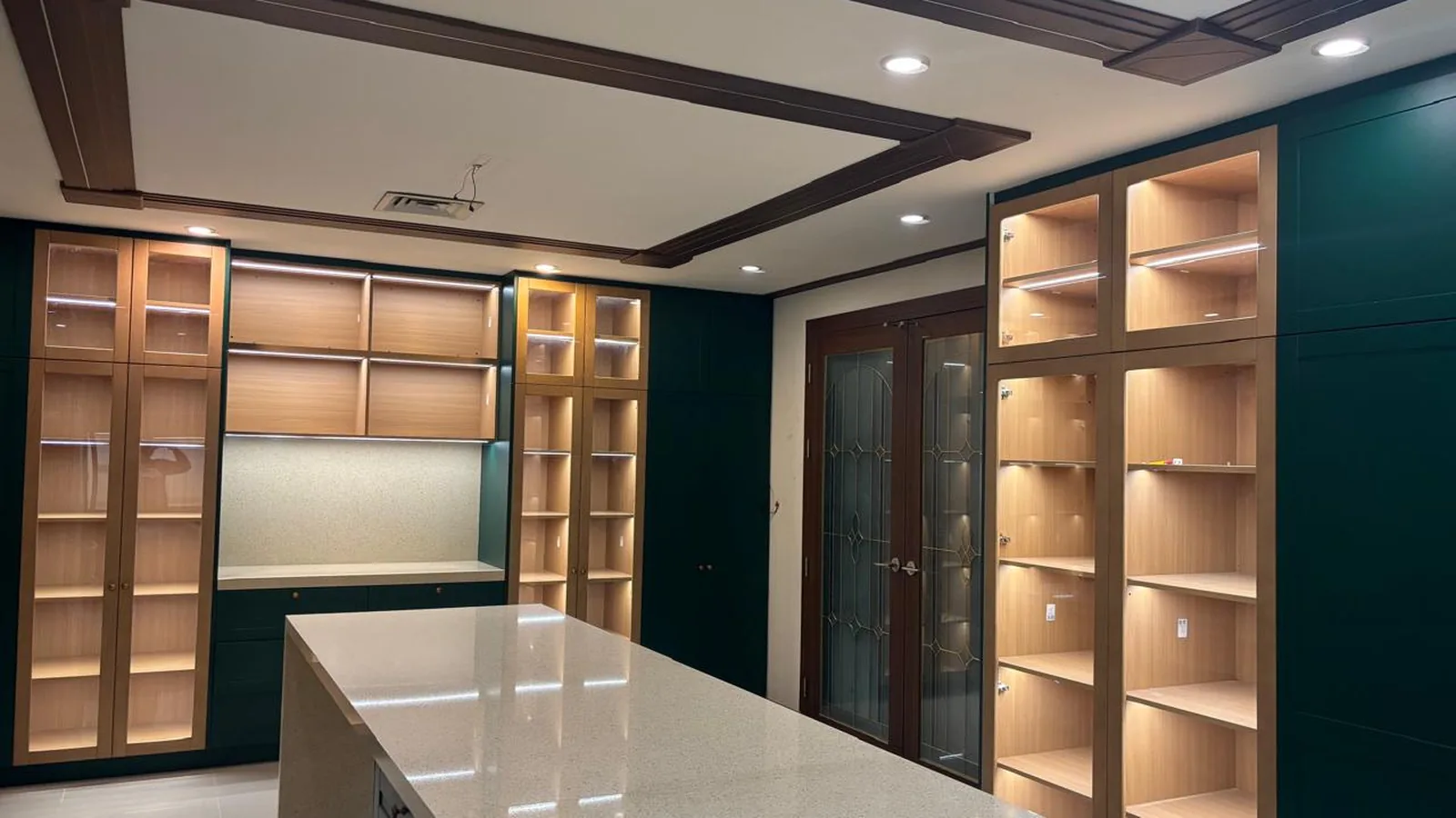 Kitchen island in green with quartz top and seating overhang