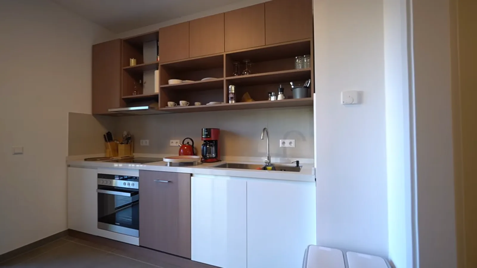 Apartment kitchen with melamine carcass, timber-tone doors and stone countertop