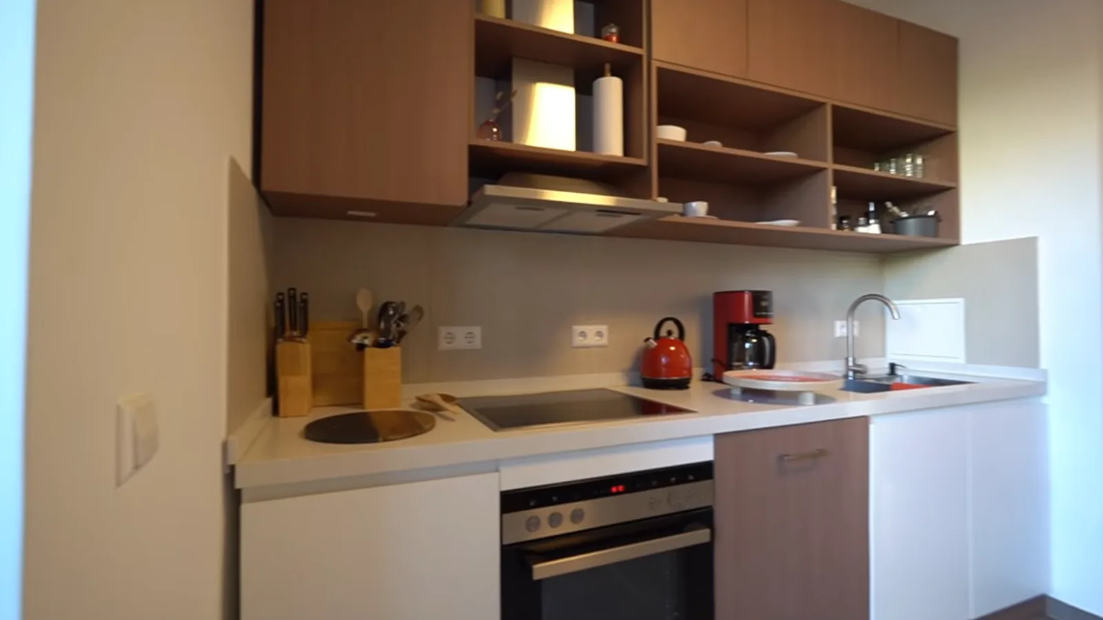 Apartment kitchen run with stone countertop and integrated appliances