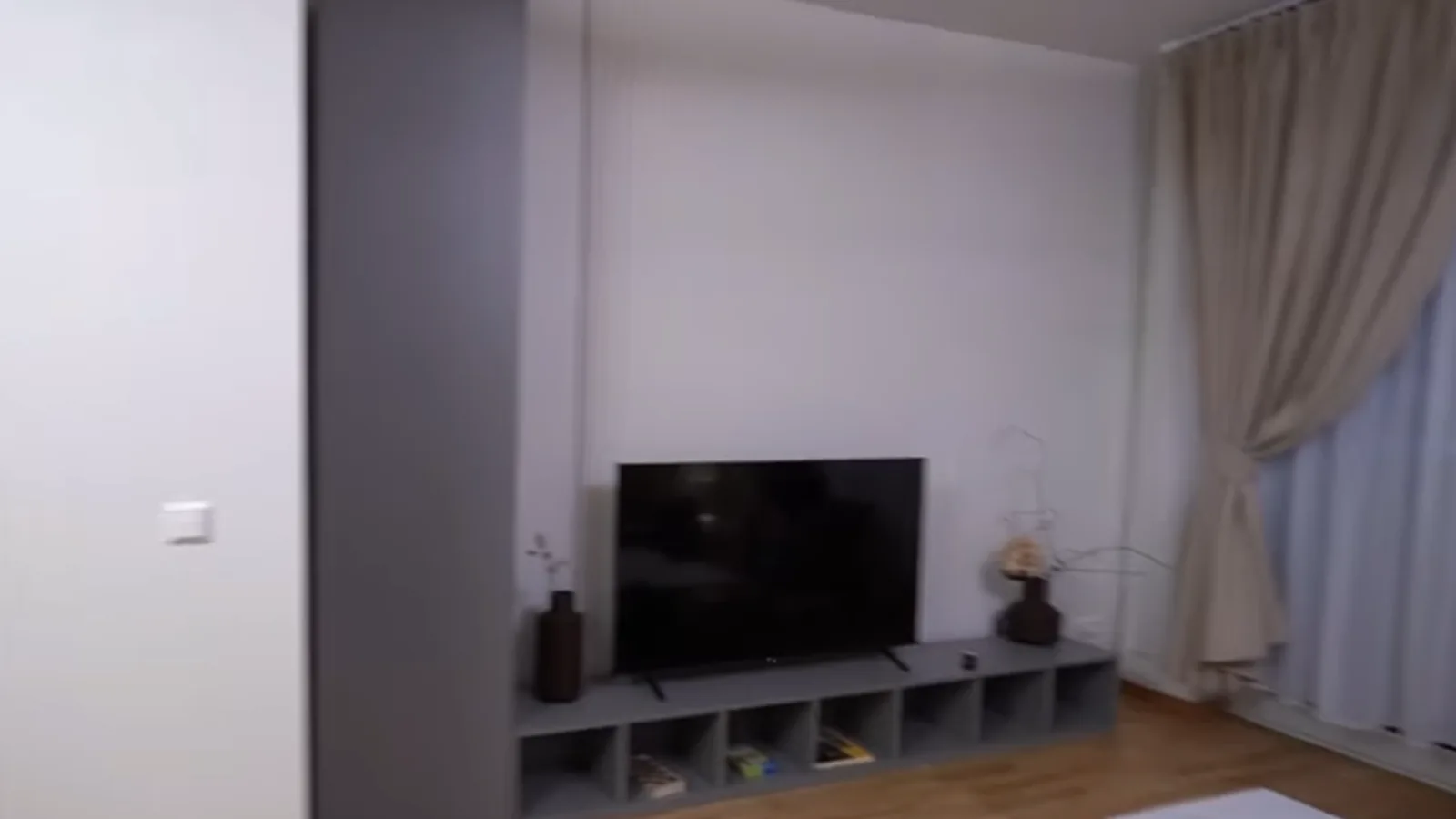 Grey living-room media wall with open shelving, built for a German apartment project