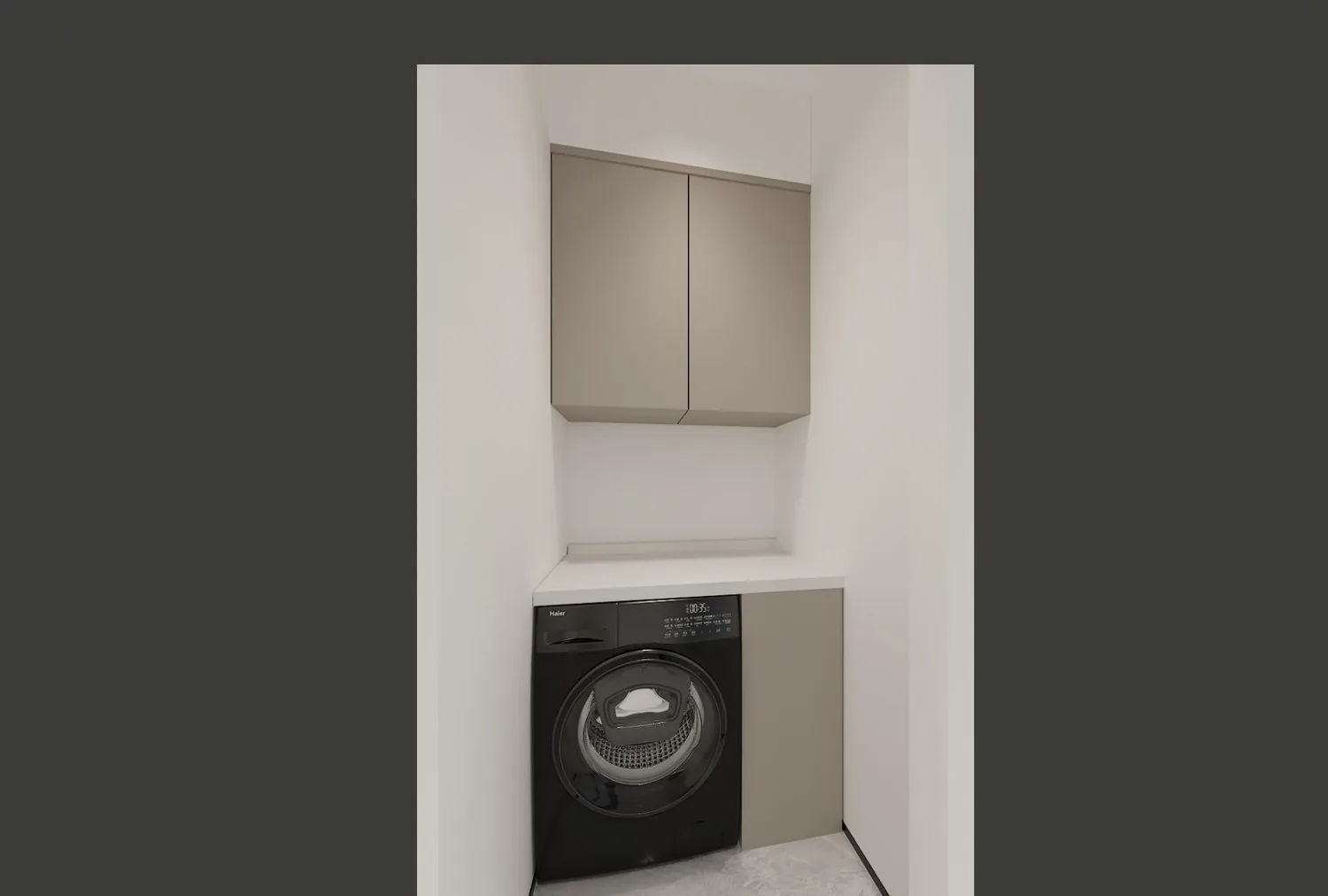 Laundry nook with built-in gray cabinet and front-load washer