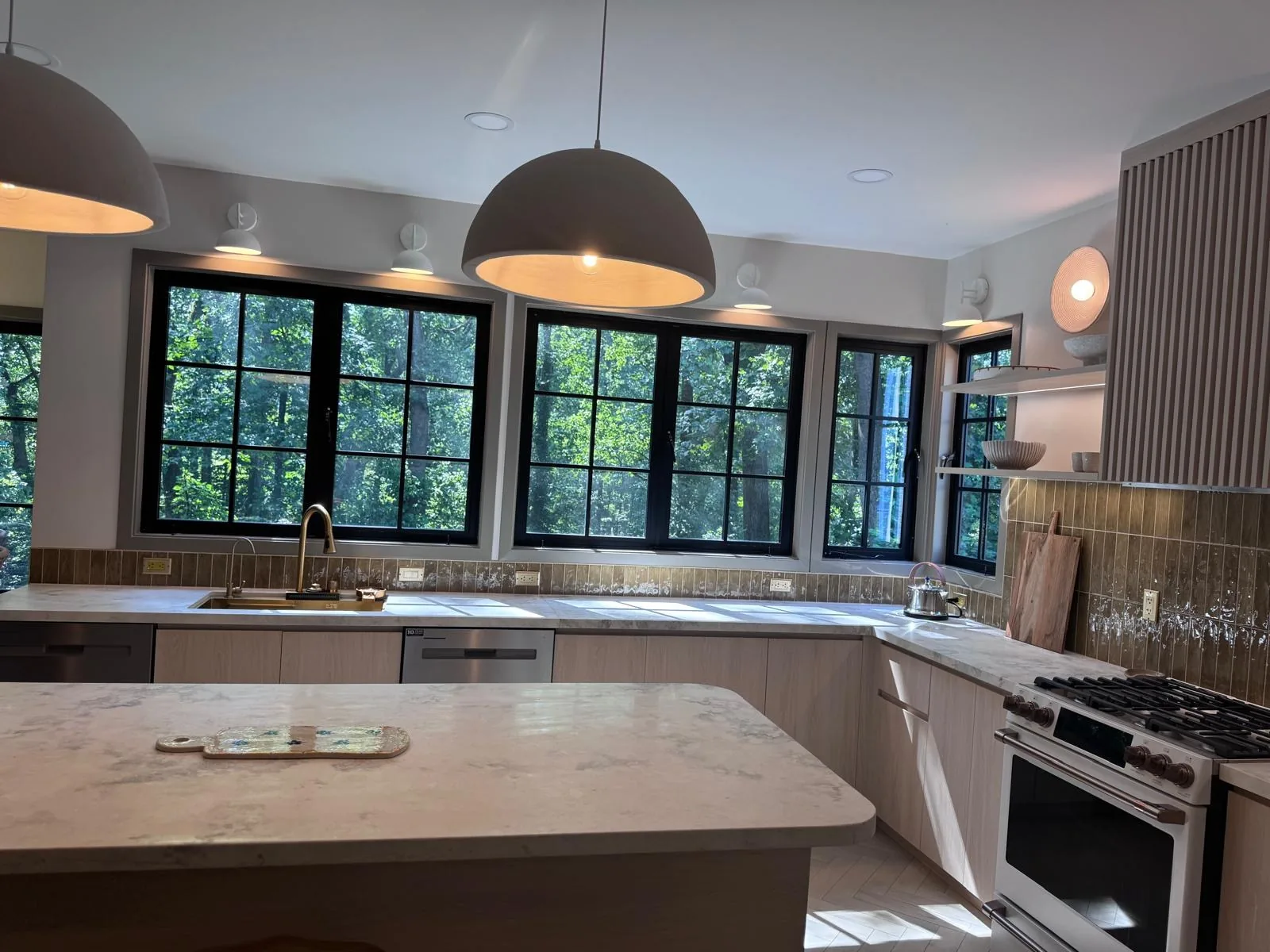 Great room with stone counter, round table and black pendants