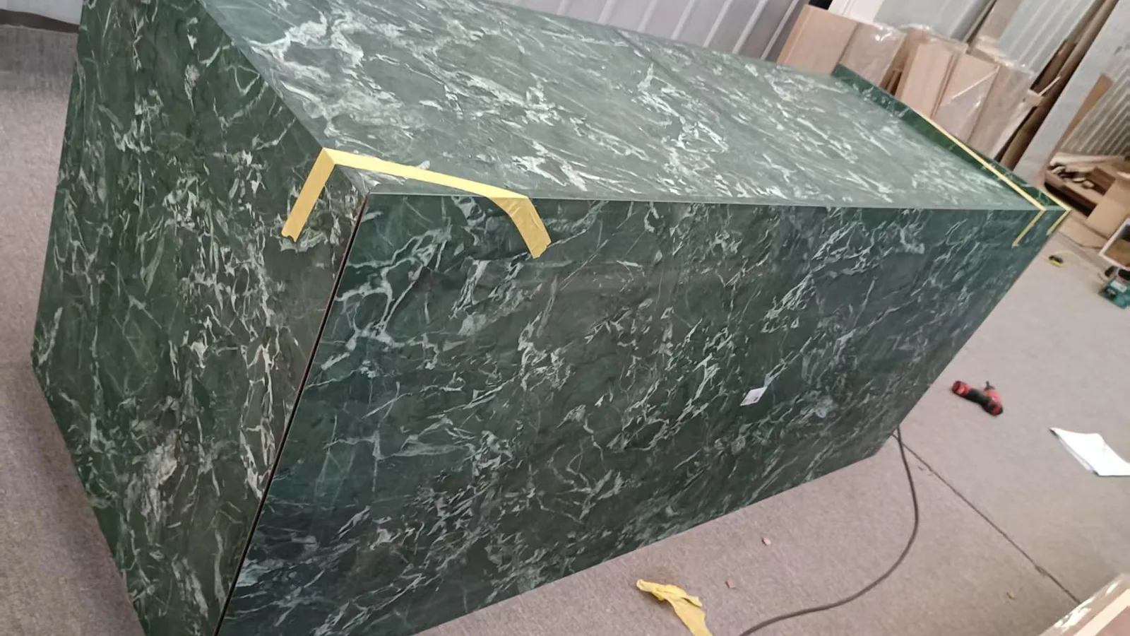 Green marble-patterned island and bar cabinet carcass in the workshop