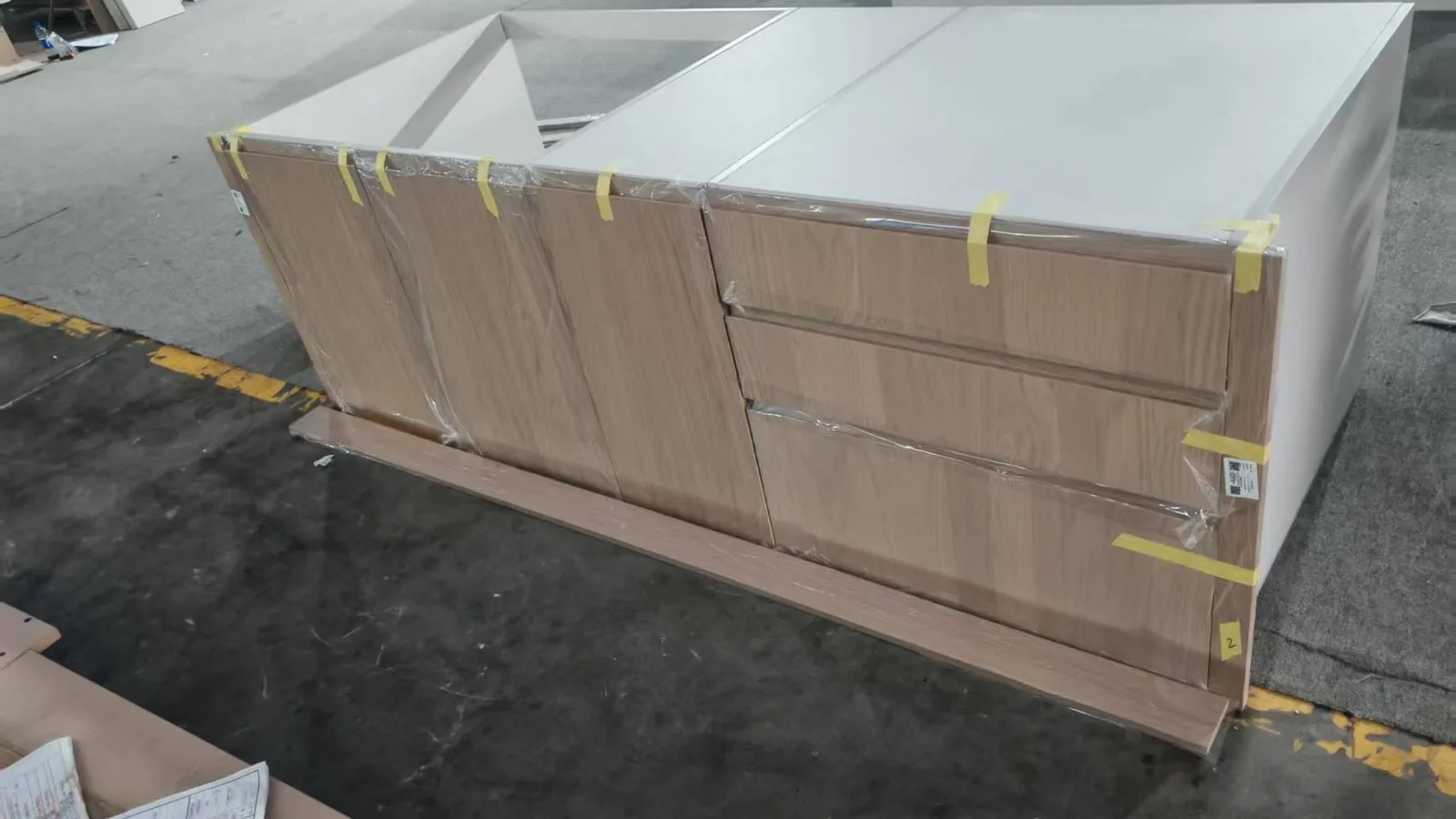 Wrapped kitchen island unit on the factory floor, protected for shipment