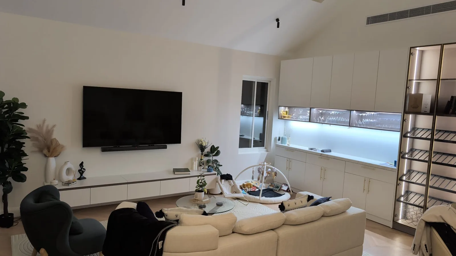 Living room with white joinery under a vaulted ceiling with skylights