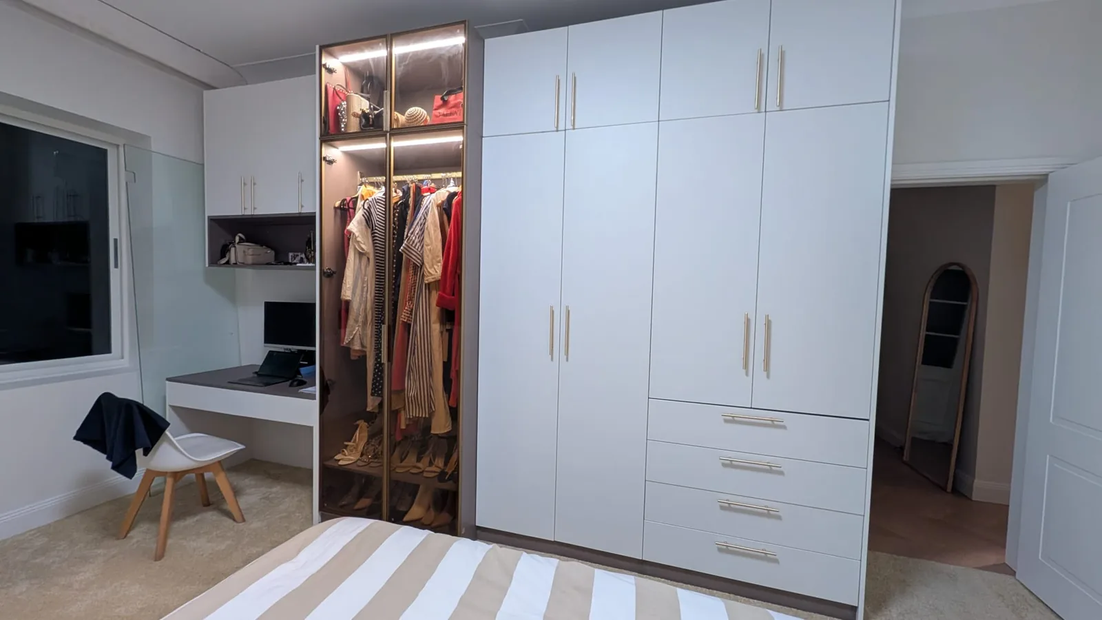 White flat-lacquer wardrobe with internal lighting in an Australian house