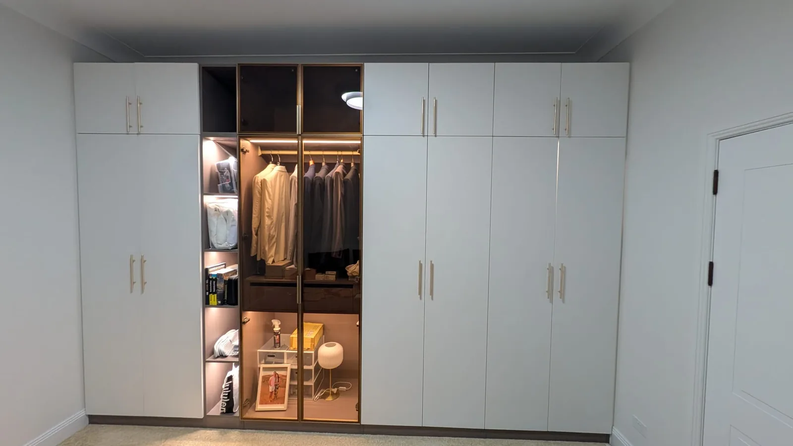 White wardrobe with open shelving and internal lighting