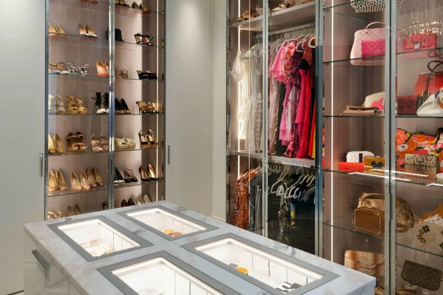Walk-in closet island with a glass-top jewelry display case