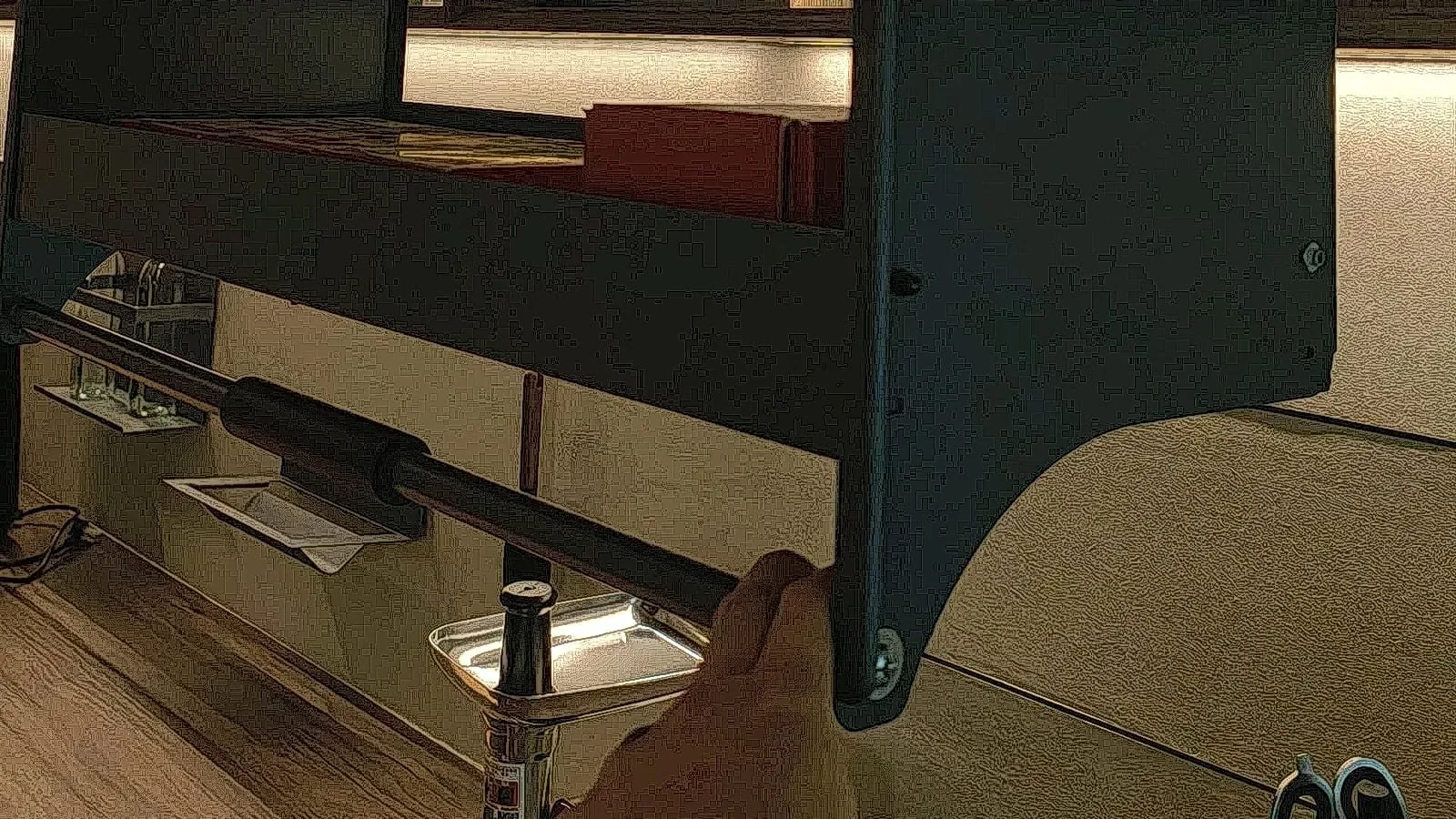 Hands fitting a hinge and drawer runner to a cabinet carcass on an assembly bench
