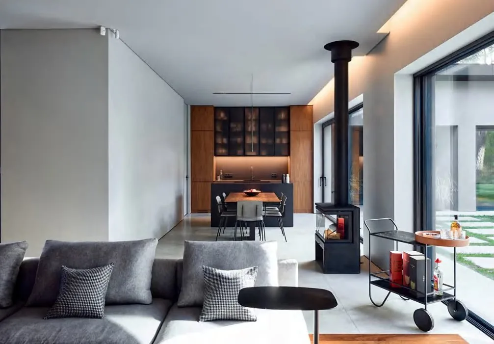 Open room with a wood kitchen run and the table in the center
