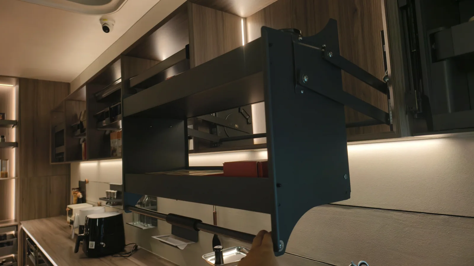 Finished dark kitchen with a black island and lit wall units