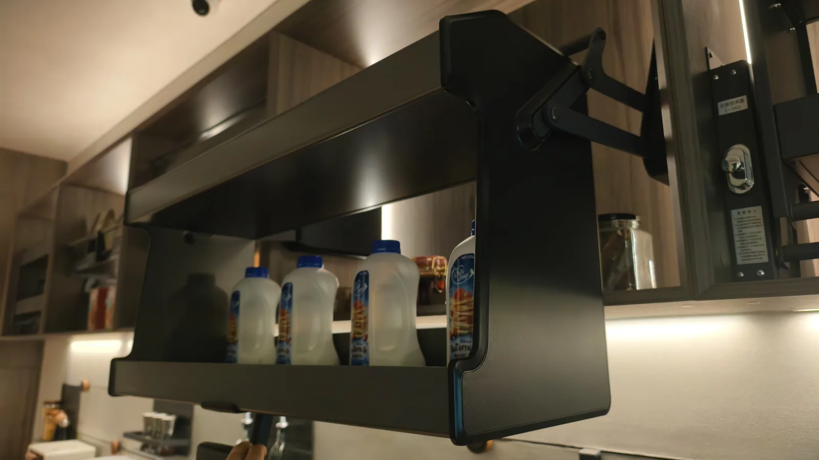 Dark fitted kitchen with tall units and a stone worktop