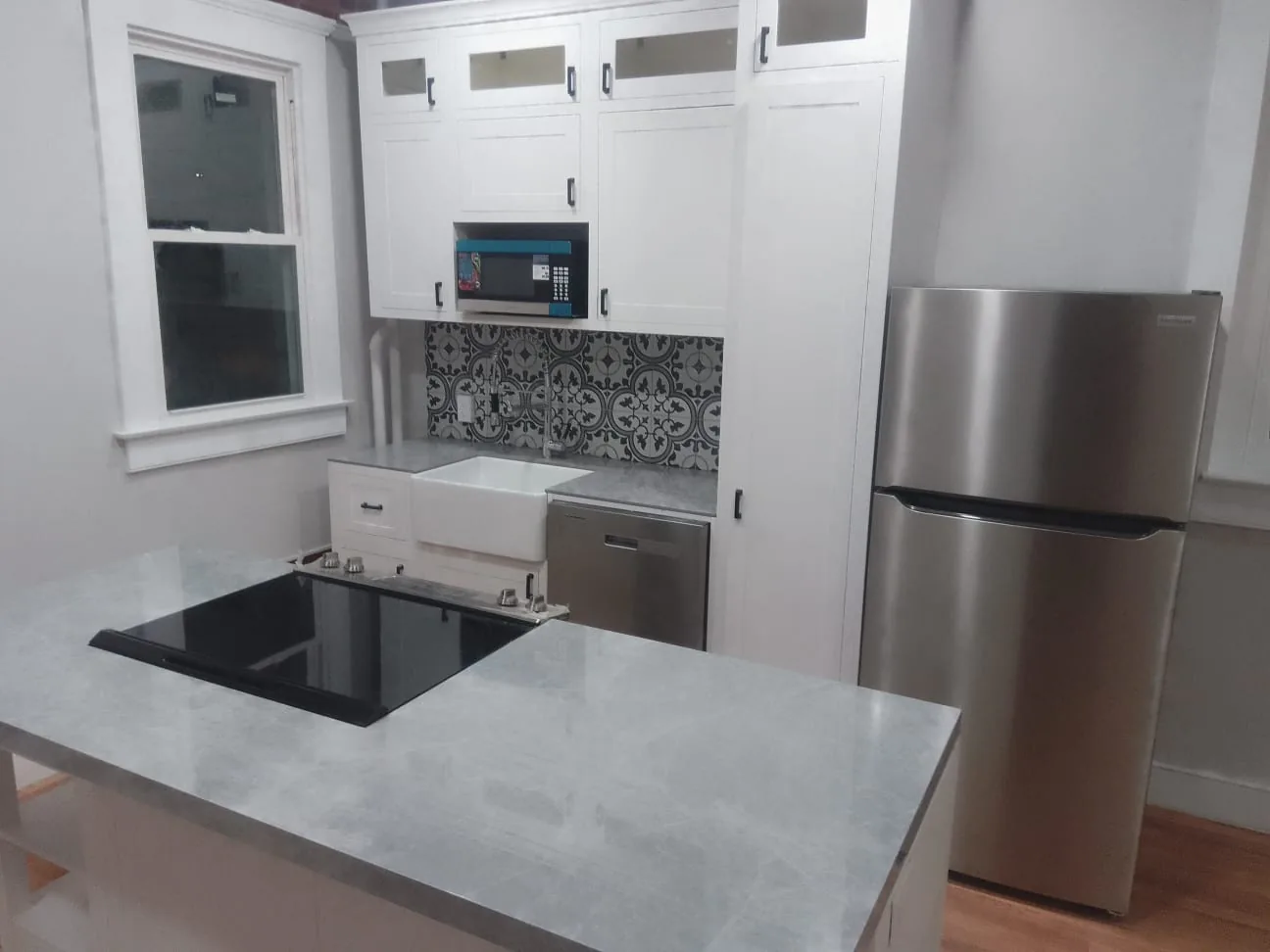 A finished US white shaker kitchen showing base cabinets, wall cabinets and a farmhouse sink