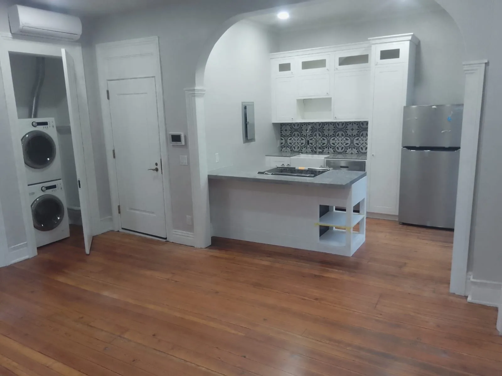 A finished US kitchen run photographed from the room, showing base and tall cabinets set back from the front counter edge