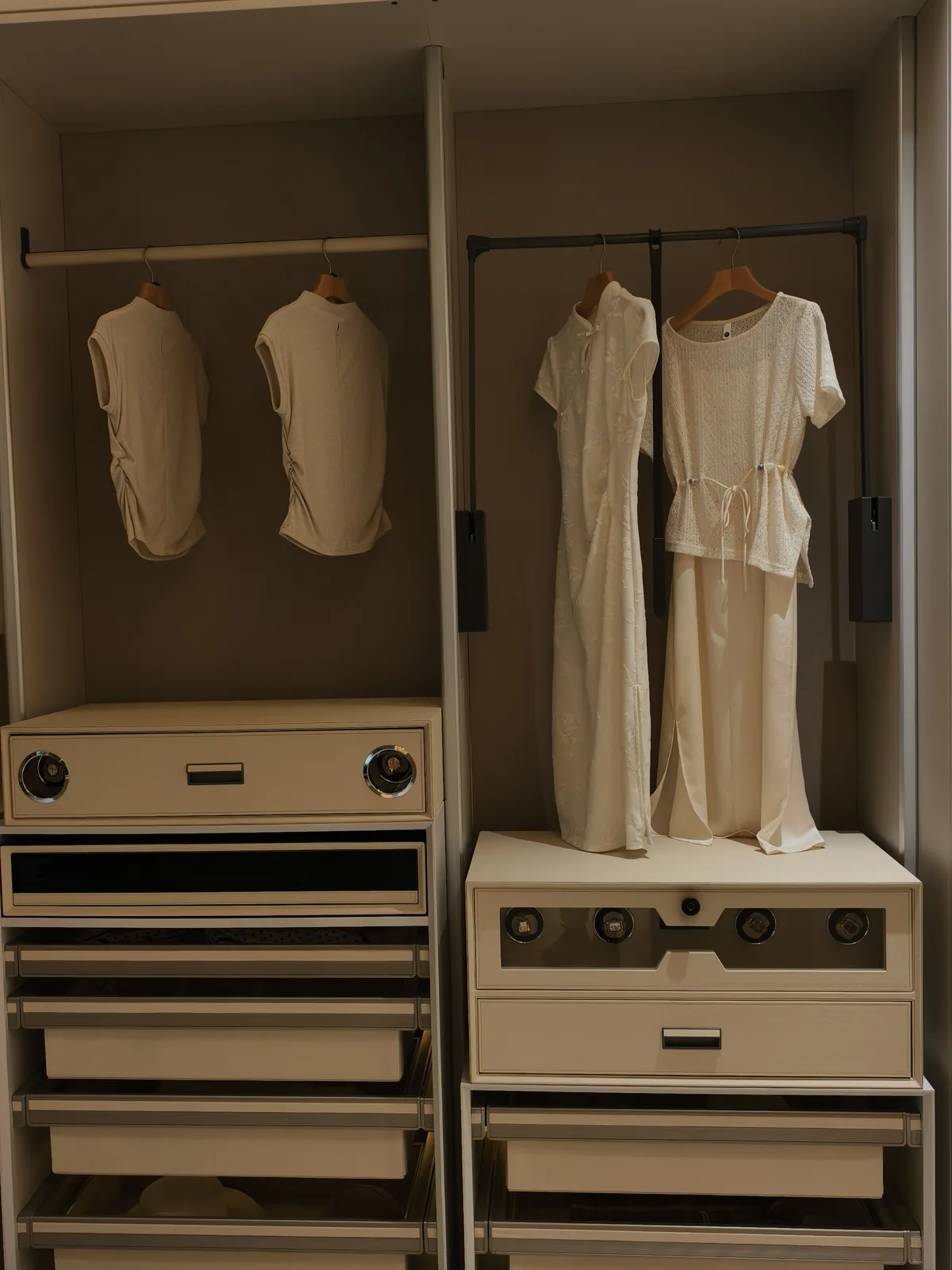 Wardrobe bay with a hanging rail holding dresses above drawer banks with fitted interiors
