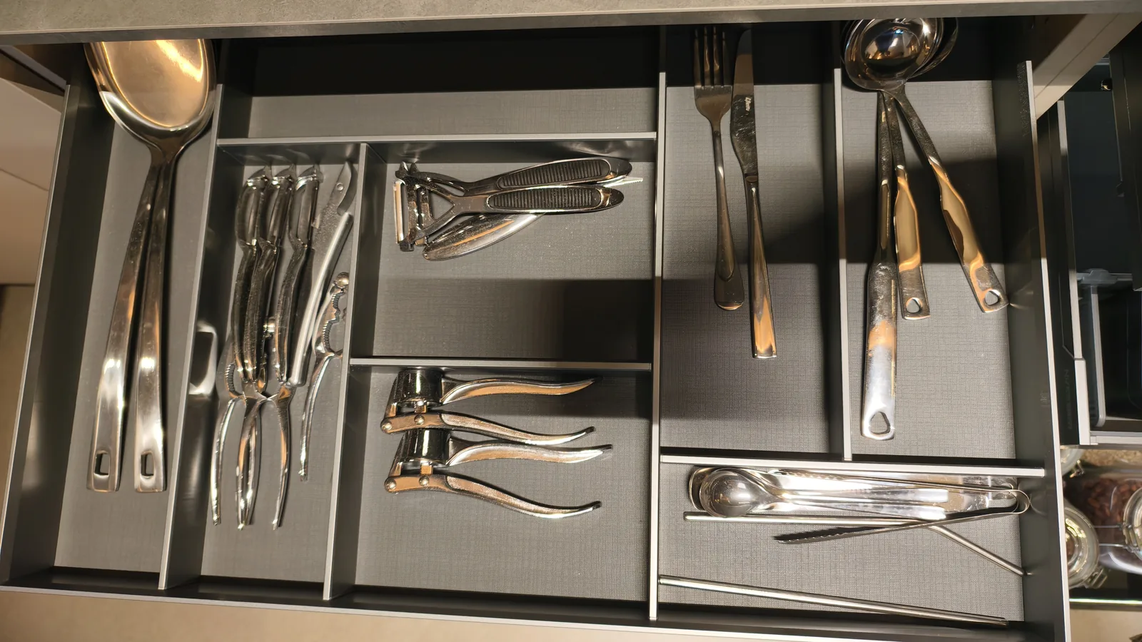 Drawer with cutlery compartments for forks, spoons and knives, photographed from above