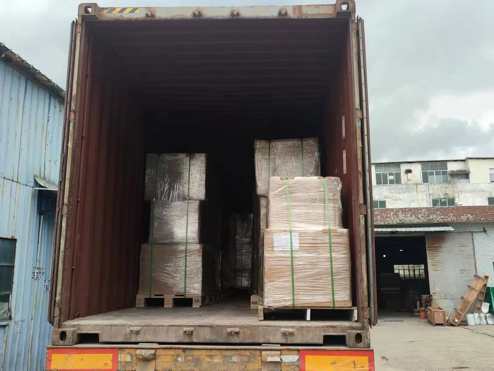 Wrapped pallets loaded inside an export container, seen through the open doors