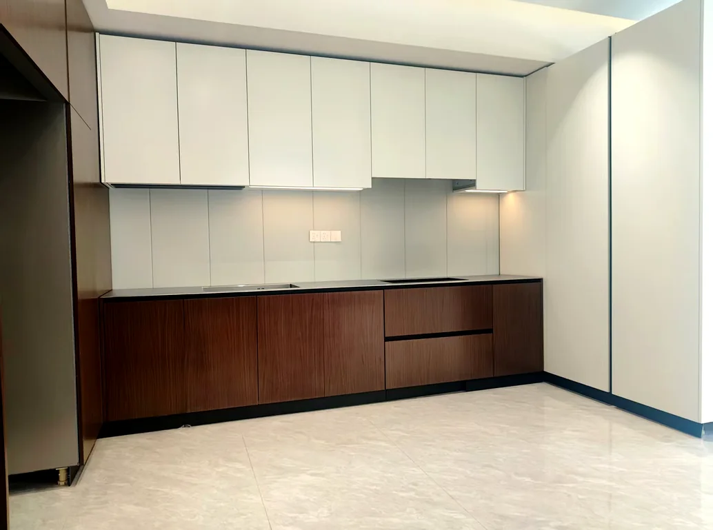 Finished kitchen run with white wall units and dark wood base units, staged before dispatch.