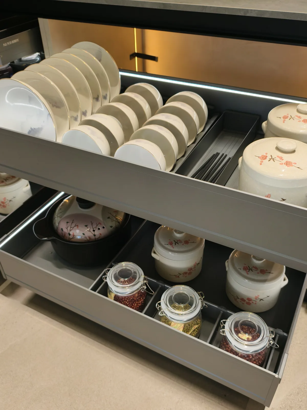 Two-tier dish rack drawer with plates, bowls and chopsticks in divided compartments