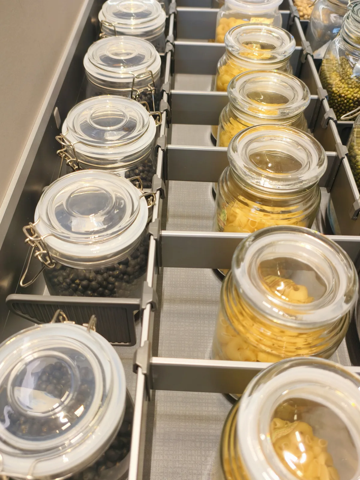 Jar drawer with glass clip-top jars standing in metal dividers