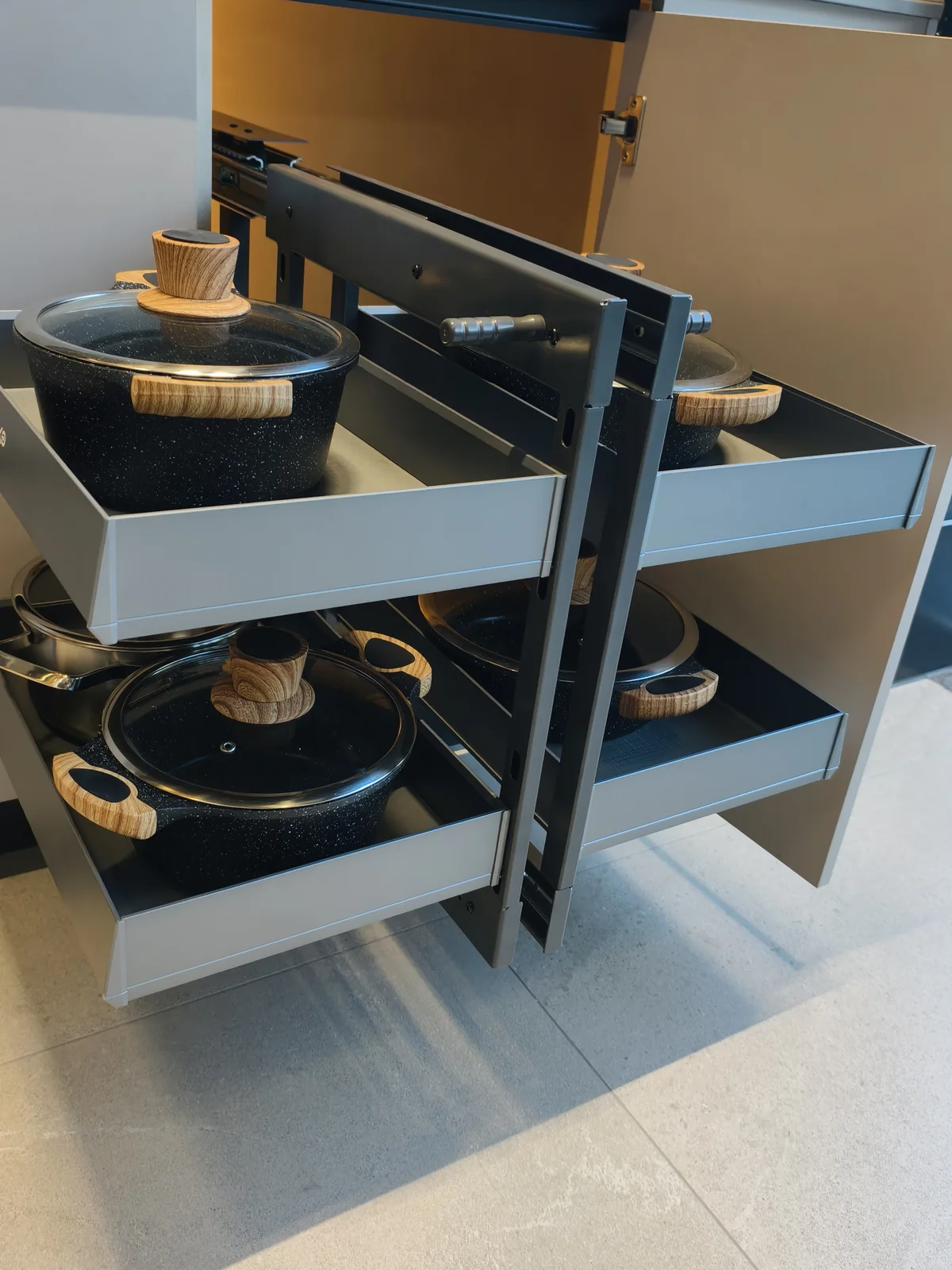 Pot drawer with two pull-out tiers holding pans with wooden handles