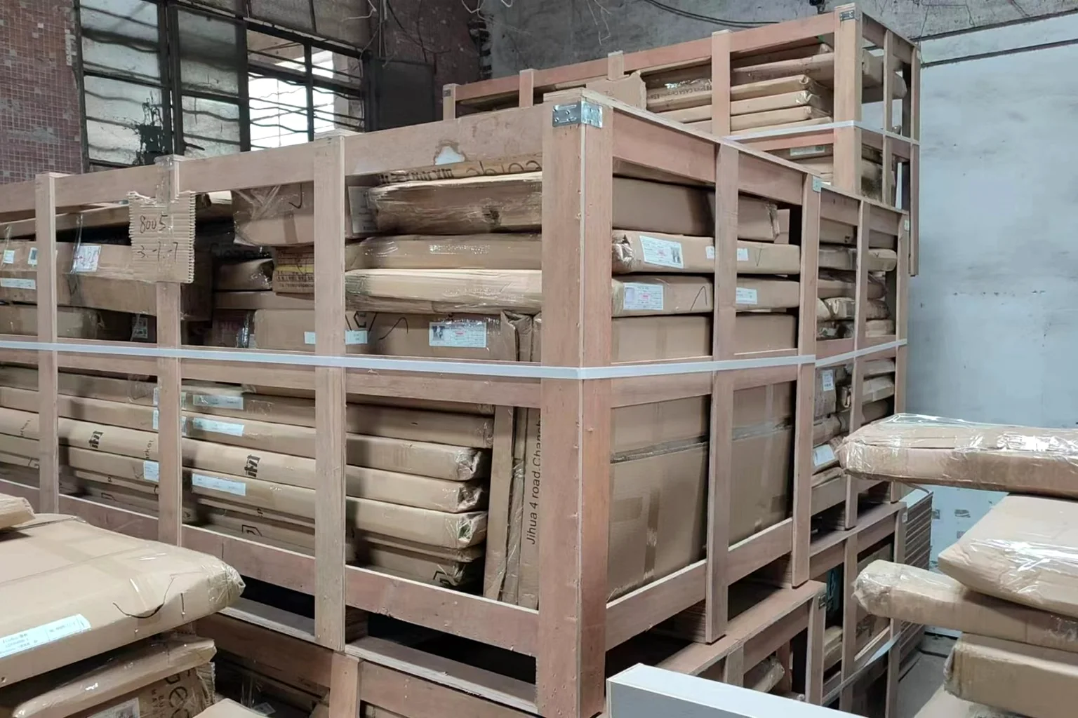 Timber-frame crates stacked in a cabinet factory, banded and ready for export
