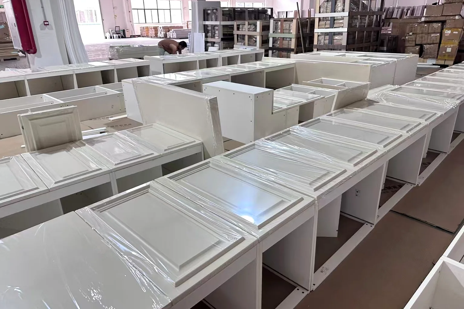 White shaker door fronts racked in the workshop before packing